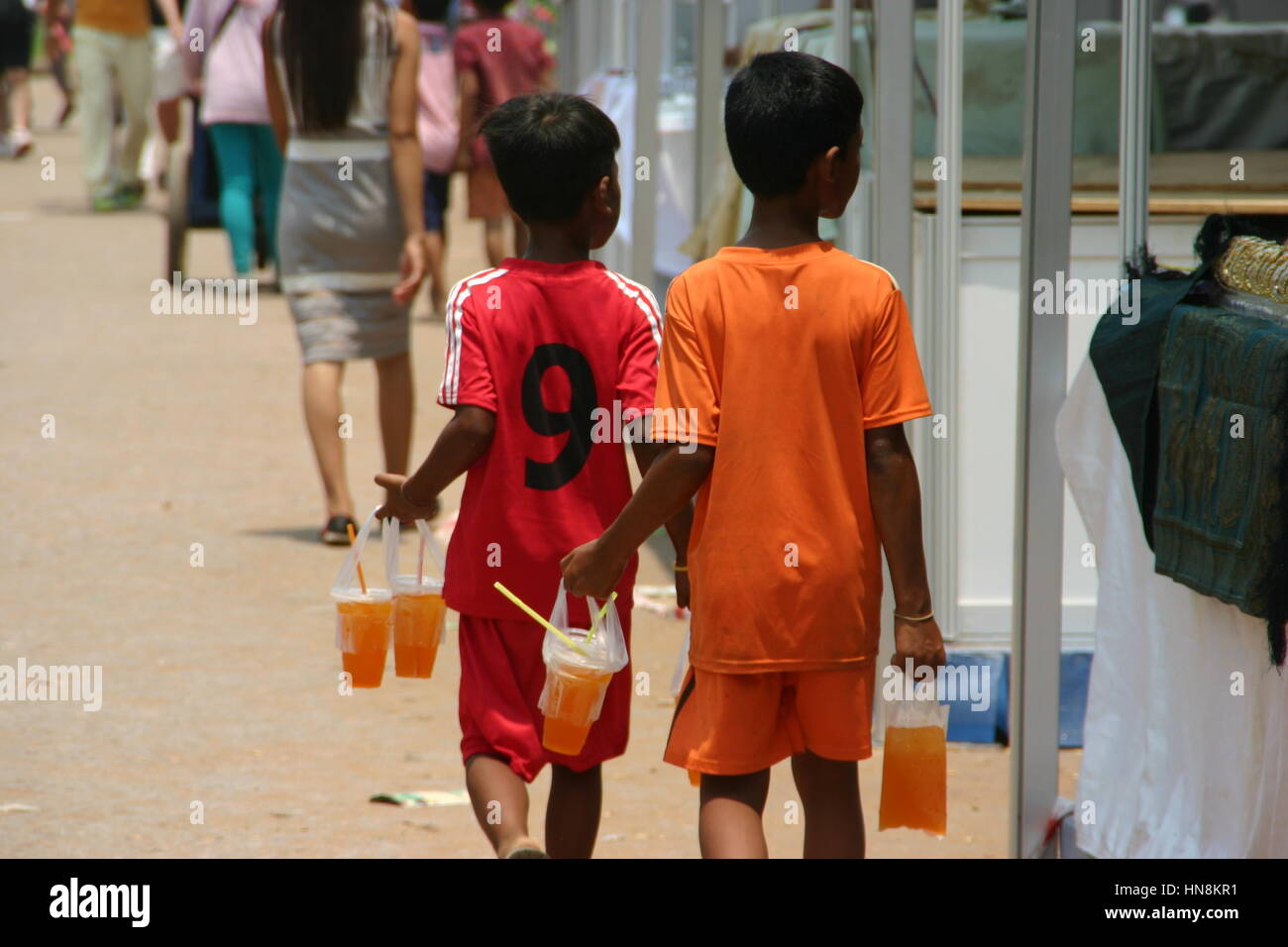 Childhood friends selling orange juice to passers by in Cambodia Stock Photo Alamy