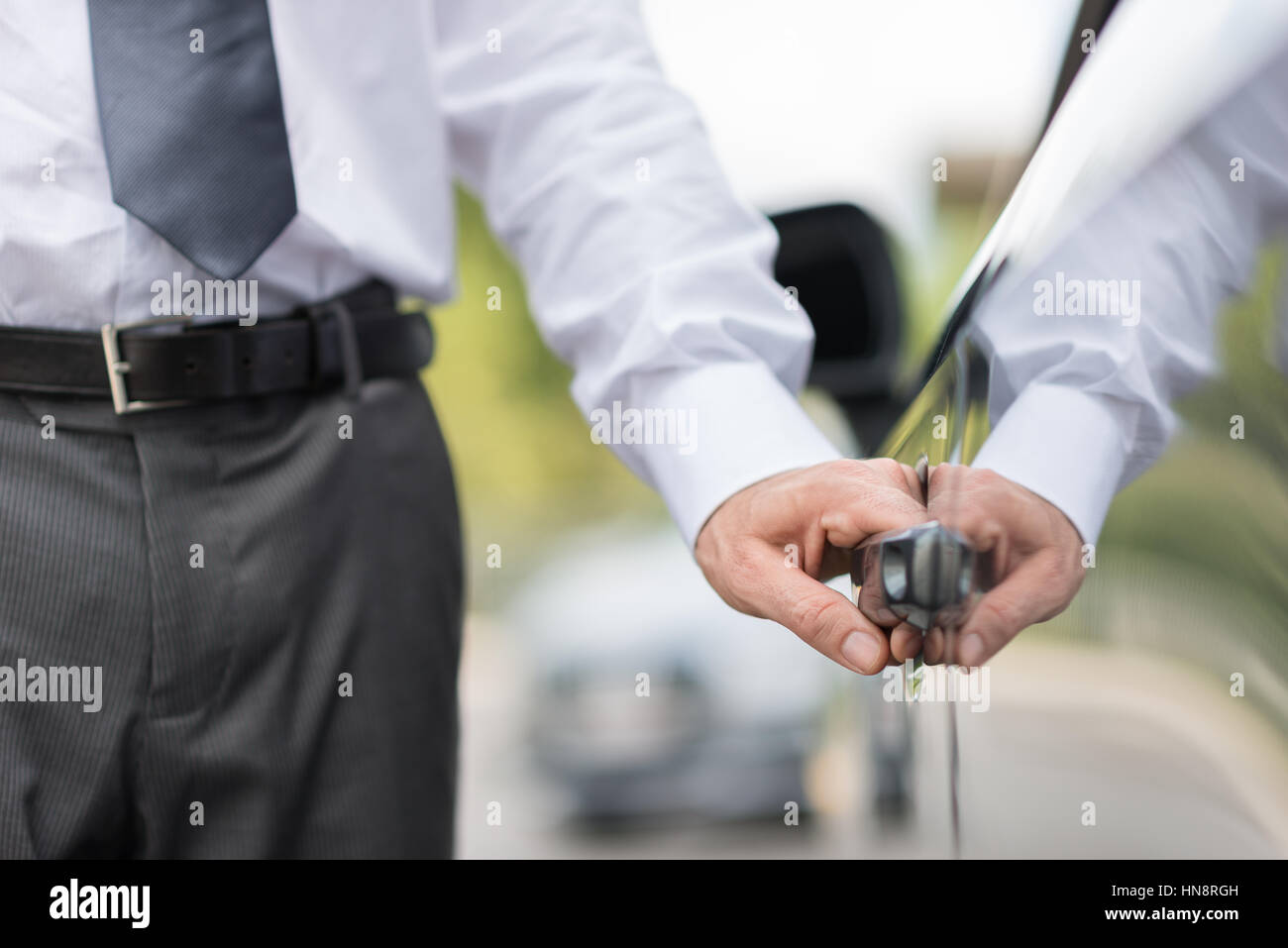 Businessman opening a car door, hand on handle close up, business and