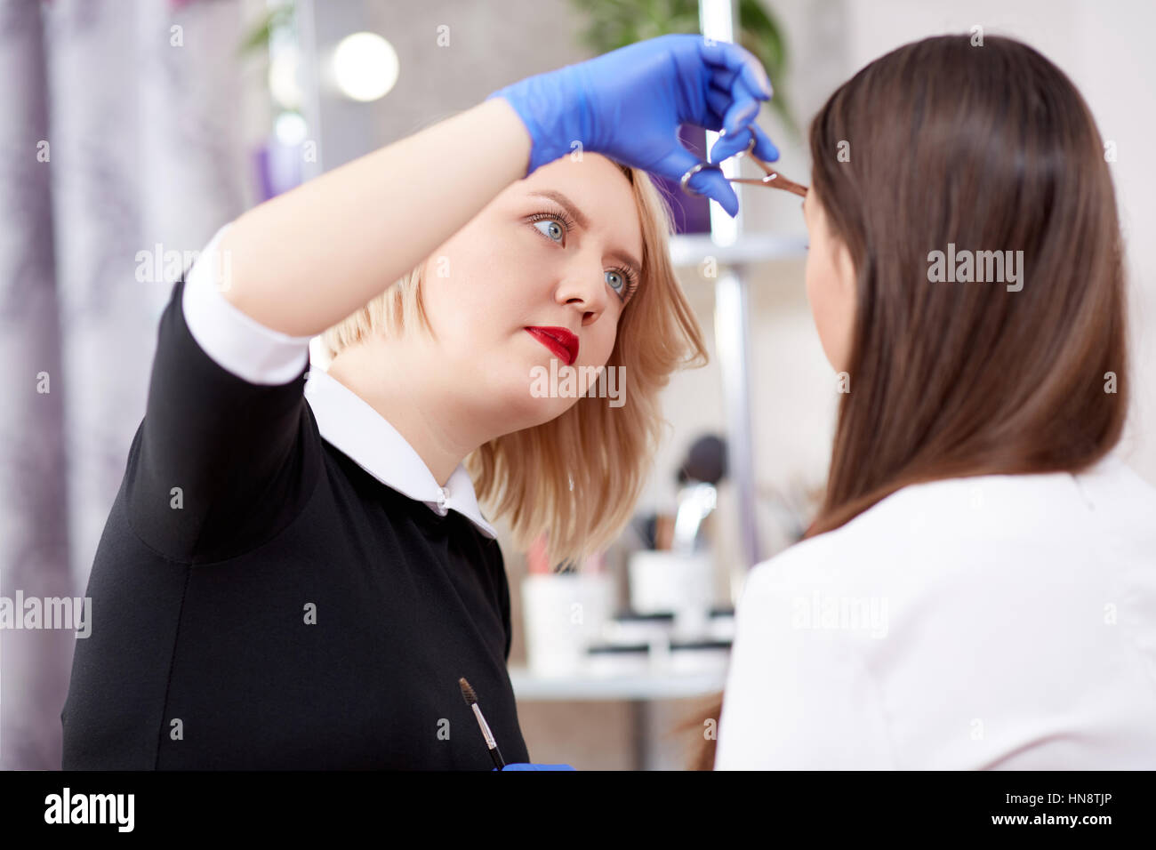 Blonde Hair Stylist Cut Off Hair With Scissors For Brunette Client
