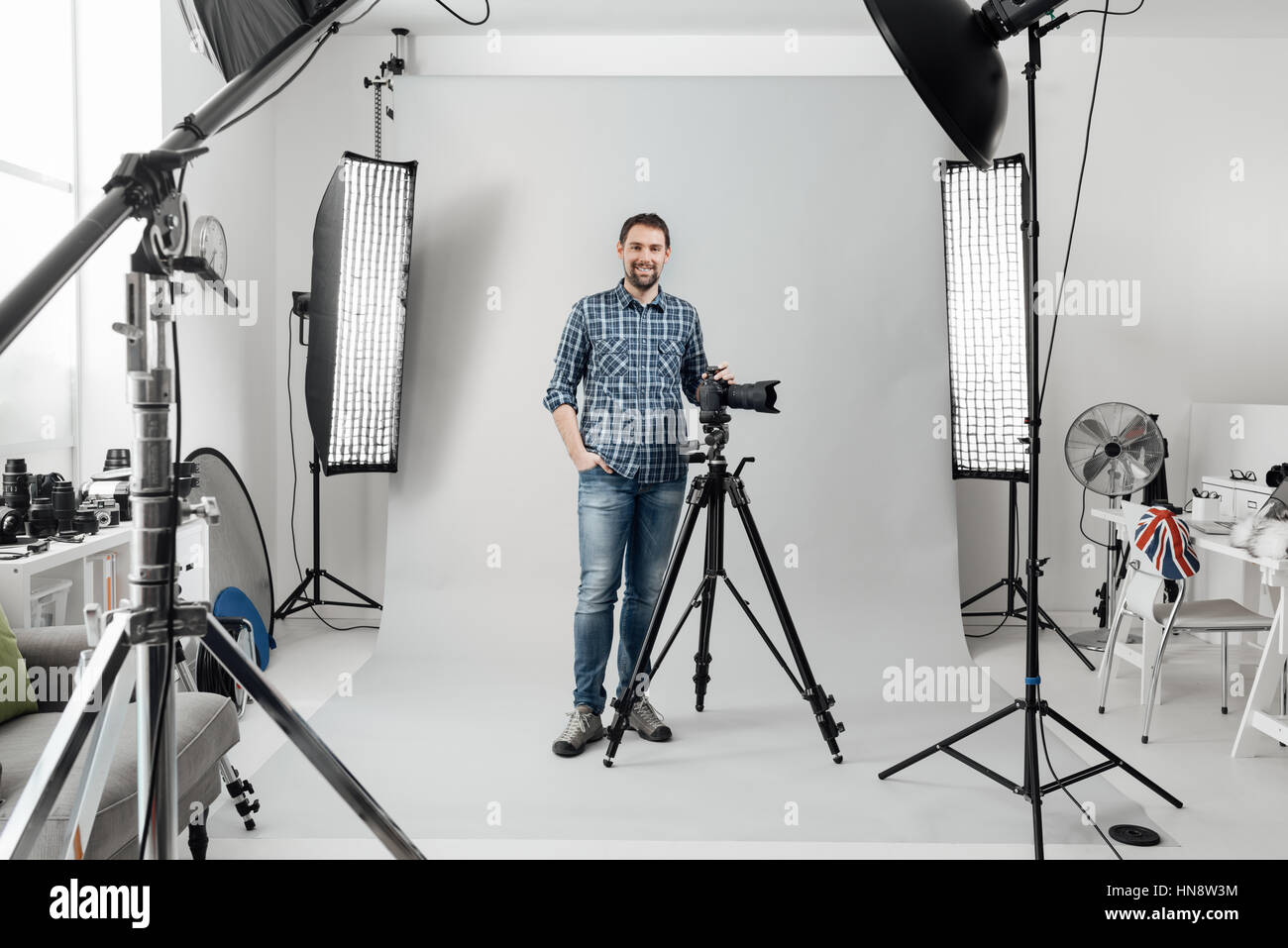 Professional photographer posing in the studio and holding a digital  camera, he is ready for the photo shoot Stock Photo - Alamy