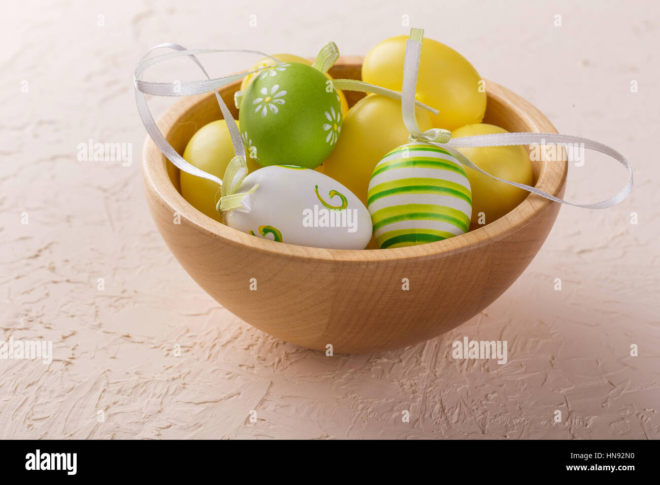 Green and yellow Easter eggs in a wooden bowl Stock Photo - Alamy
