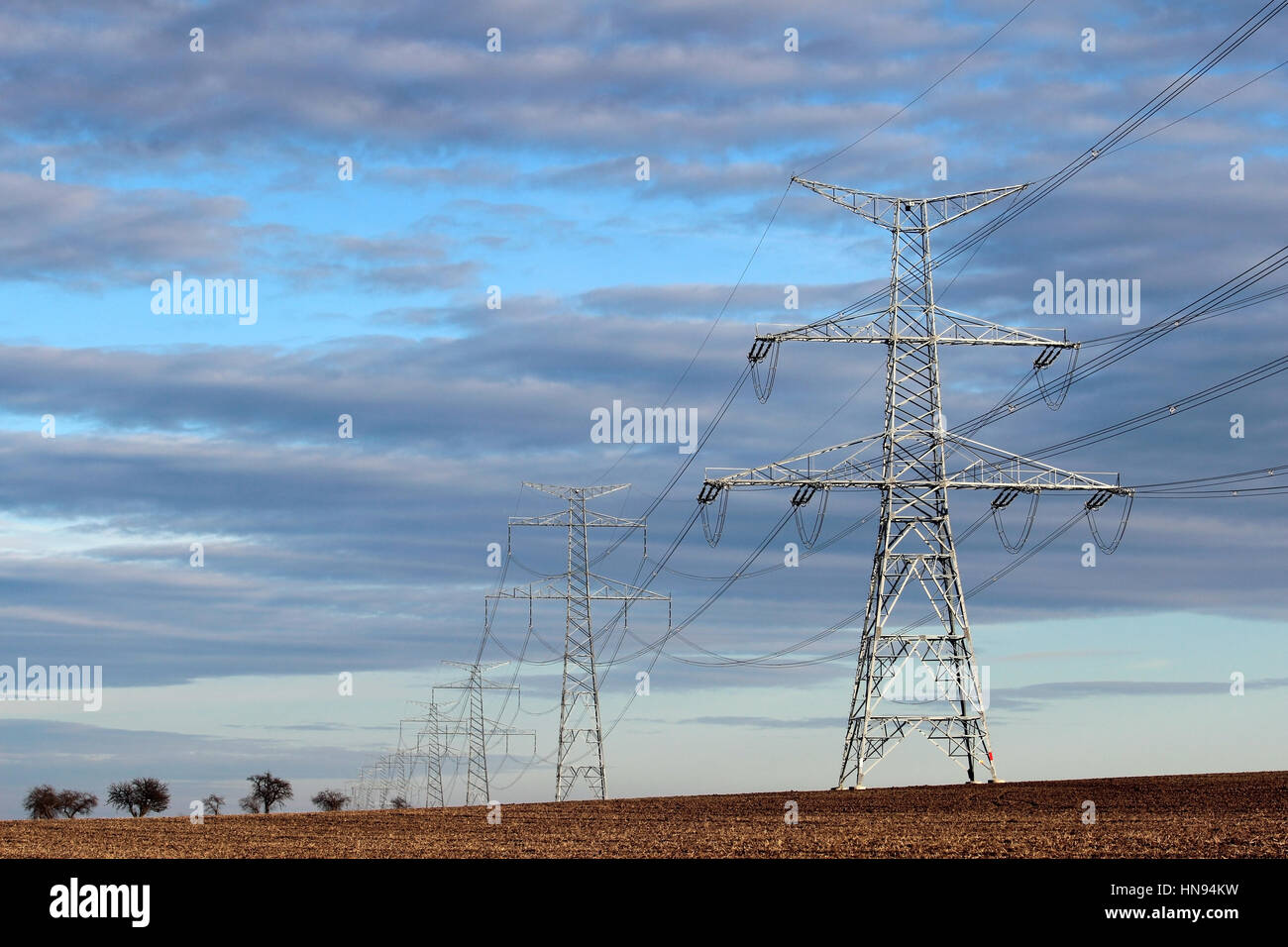 high voltage electric transmission pylon on agriculture field Stock Photo