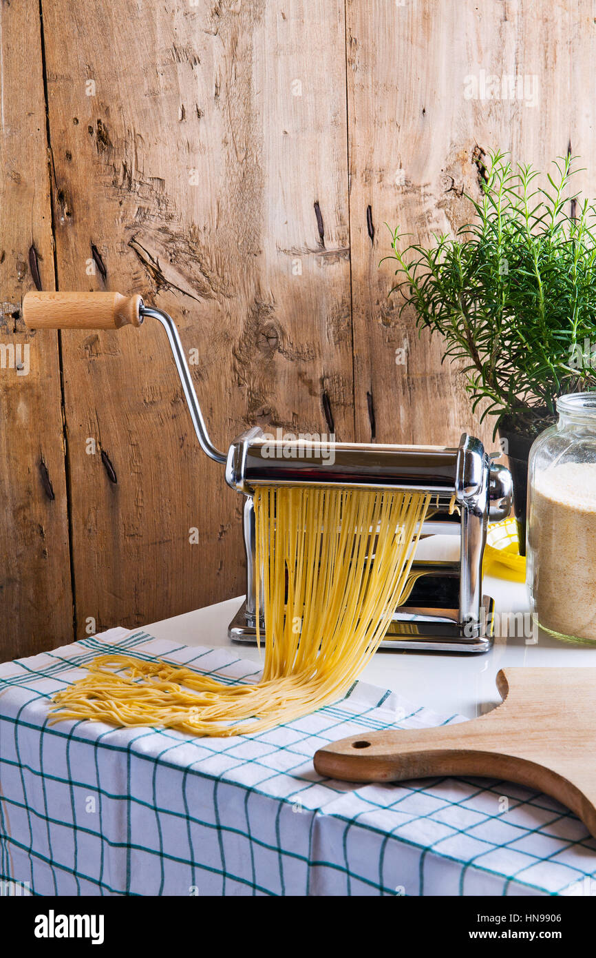 to make spaghetti with pasta machine. female hands Stock Photo Alamy