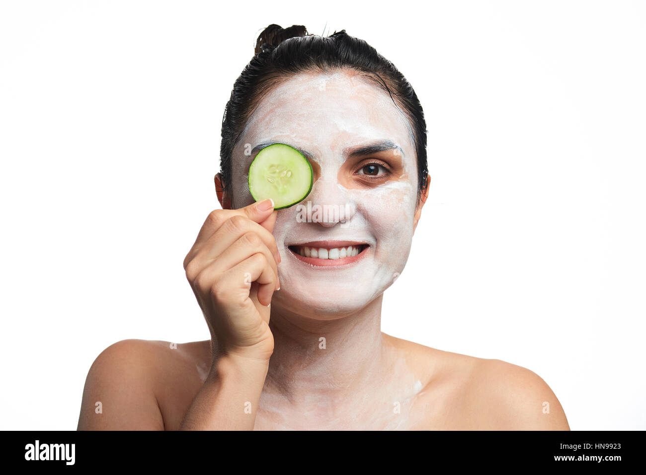 girl cover one eye with cucumber and cream on face isolated white Stock Photo