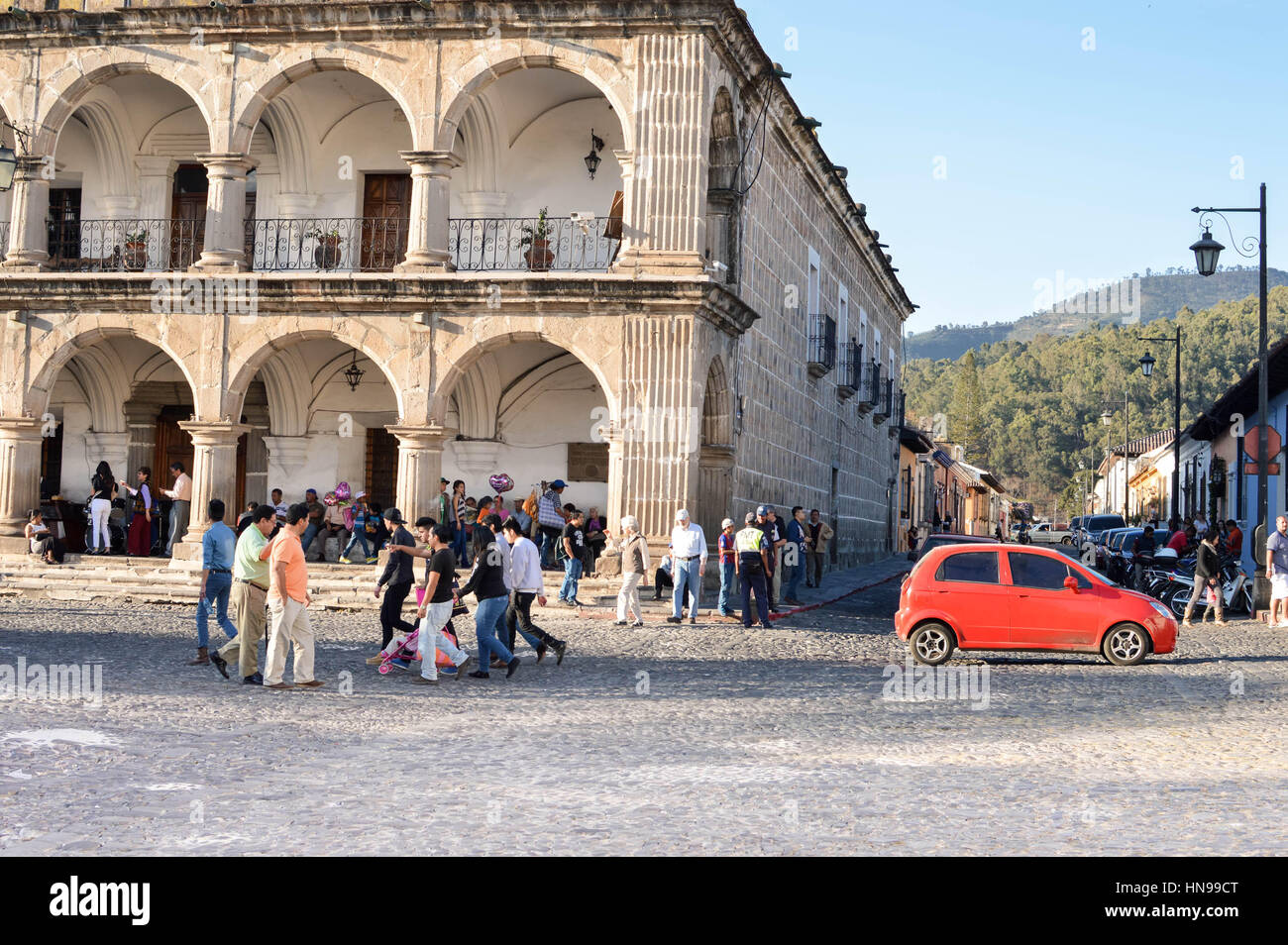 Antigua, Guatemala - February 15, 2015: People are seen walking the cobble stone roads by the main Plaza of Antigua, Guatemala Stock Photo