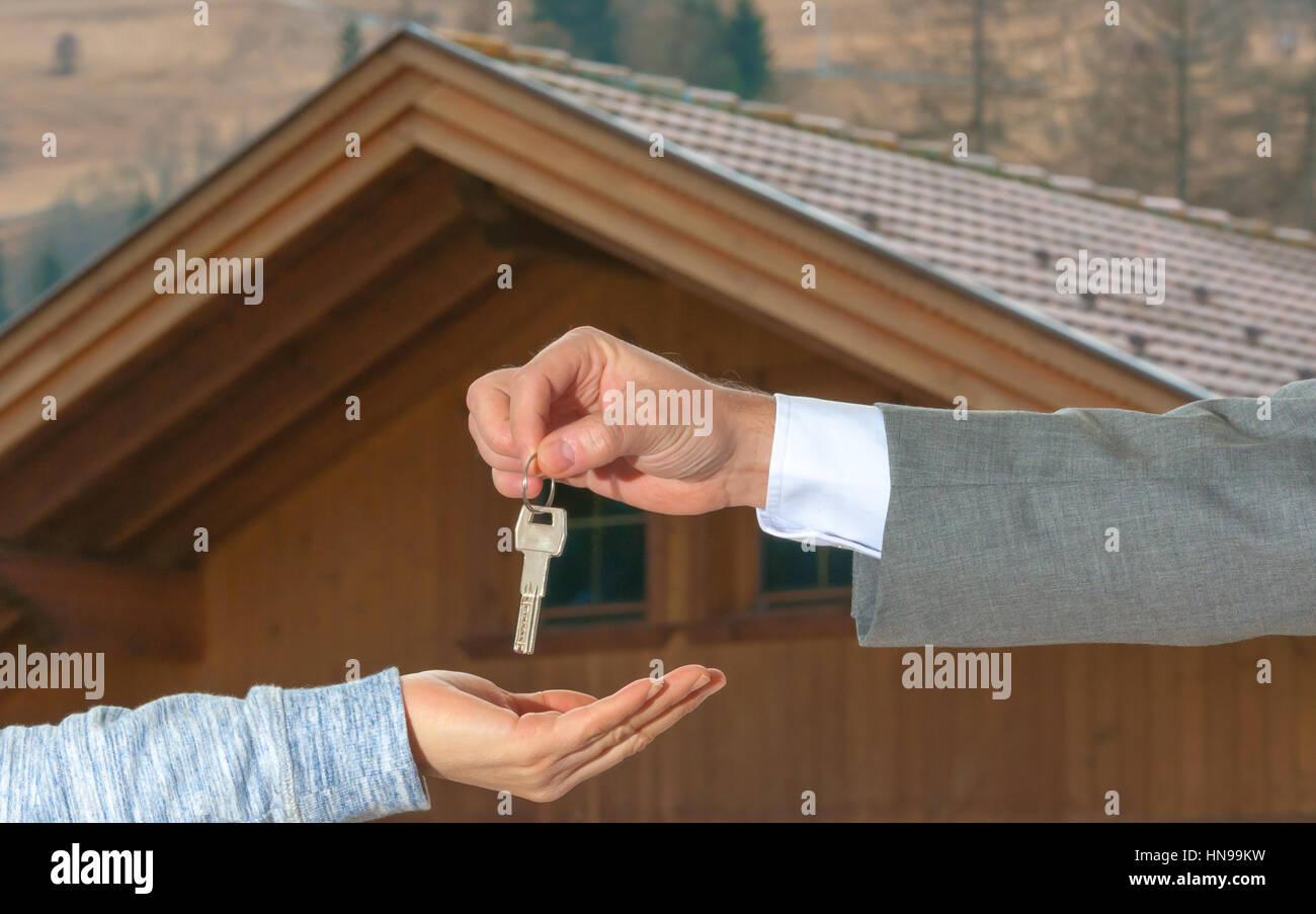 Closeup shot of a female hand receiving house key. Close up hand holding house key. Stock Photo