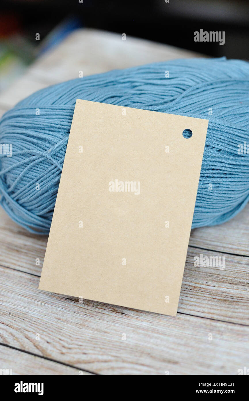 Blank label closeup next to a ball of knitting yarn Stock Photo
