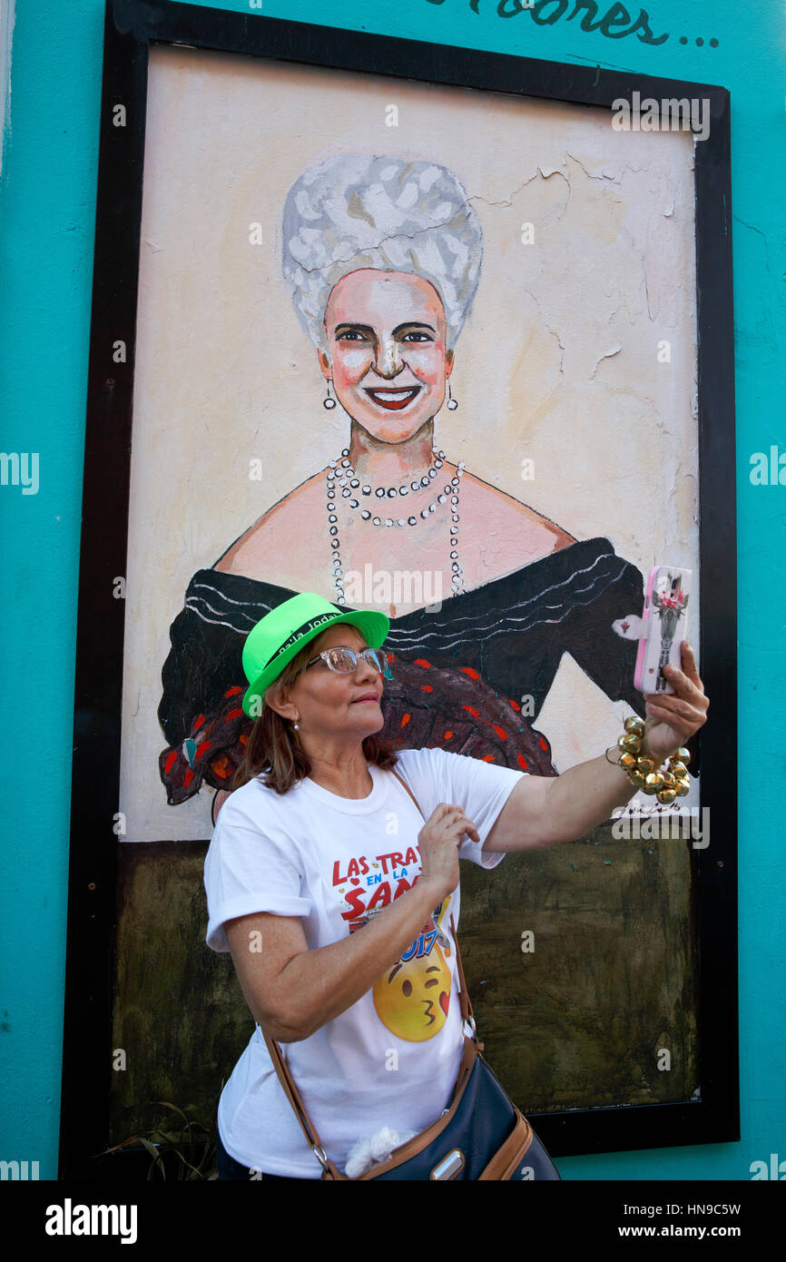 A woman taking a selfie with a painting of the first woman mayor of San Juan Felisa Rincón de Gautier on a building in San Juan, Puerto Rico Stock Photo