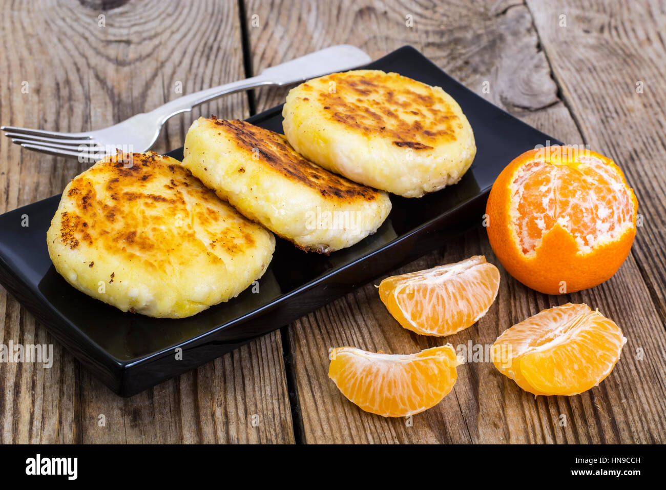 Hot sweet cheesecakes with tangerines and honey Stock Photo