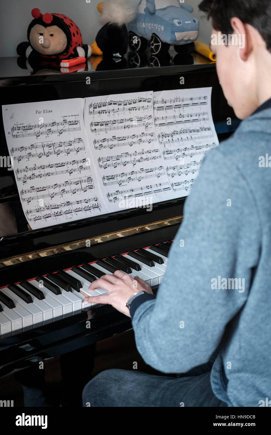 Teenage boy plays piano Stock Photo
