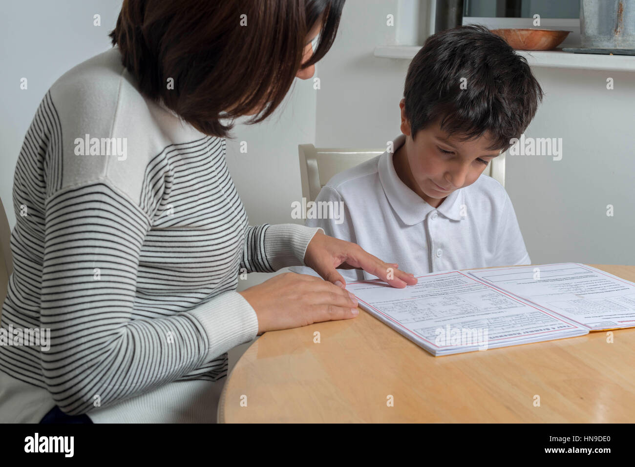 UK,schoolboy getting help with homework Stock Photo