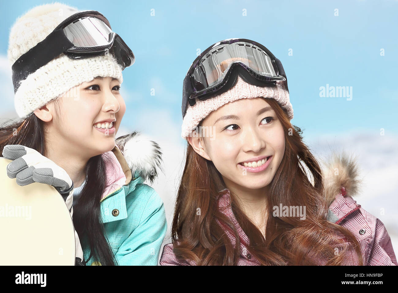 Young Japanese women snowboarding Stock Photo