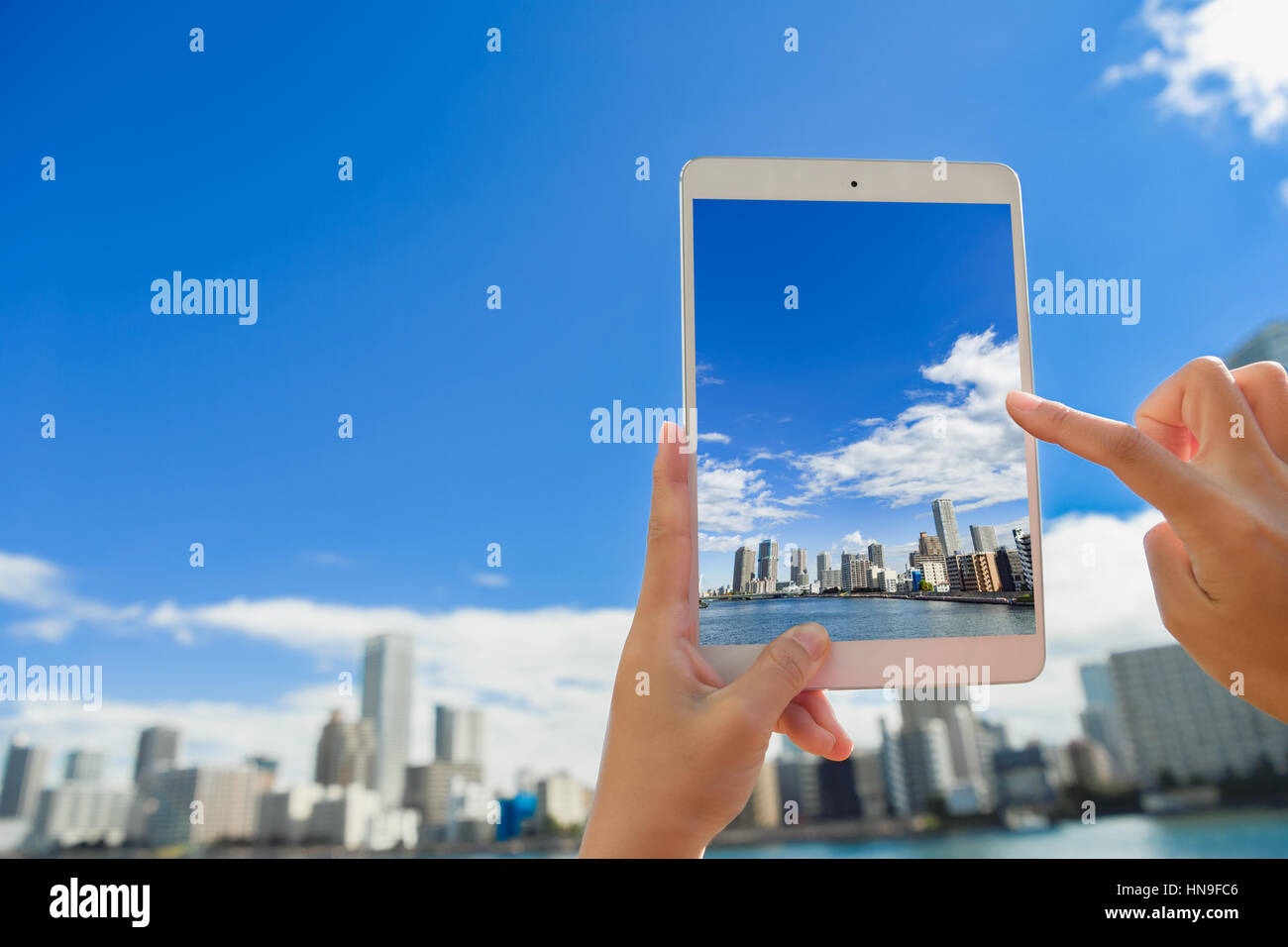 Japanese woman using augumented reality app on tablet downtown Tokyo, Japan Stock Photo