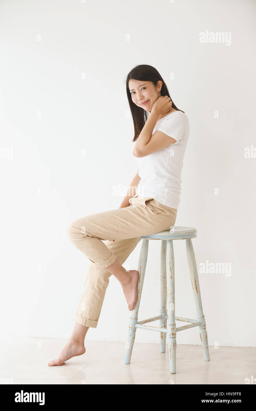 Young Japanese woman on a chair in a white room Stock Photo Alamy