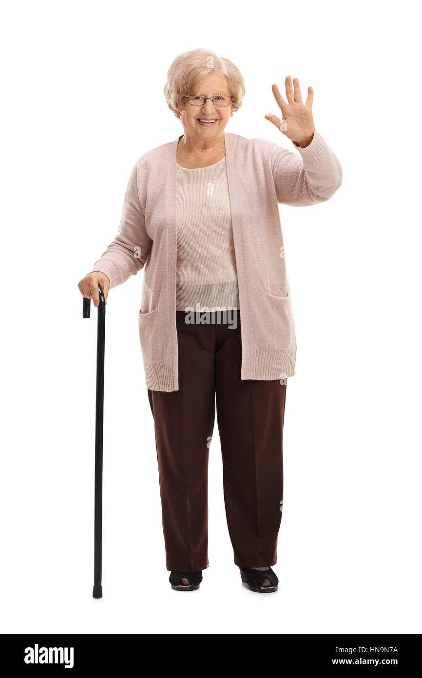 Full length portrait of an elderly woman with a walking cane waving isolated on white background Stock Photo