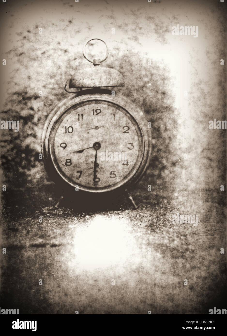 Old photo of the alarm clock - grained, scratched, overexposure and underexposure, unfocused, overall poor and non commercial Stock Photo