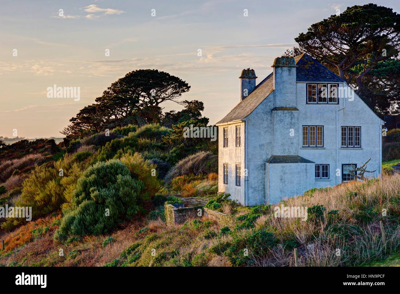 A grand old large white house uninhabited due to it's close position to the cliff edge/sea in the village of Polruan on the Fowey Estuary, Cornwall. Stock Photo