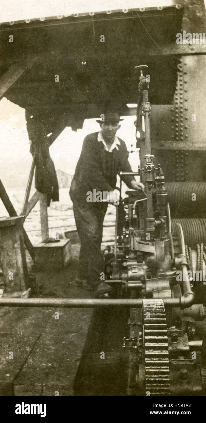 Antique c1920 photograph, man standing near steam-powered machinery USA. Stock Photo