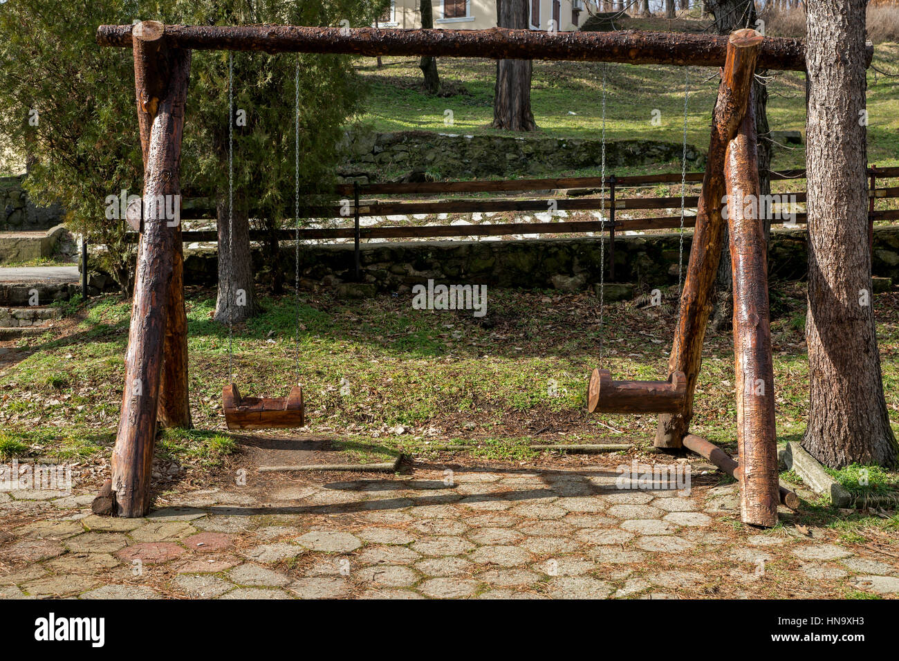 Swing made of tree trunks hung on chains Stock Photo