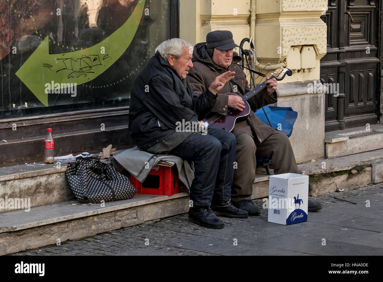 Belgrade, Serbia - February 27, 2016: Two retirees playing guitar and singing on the street Stock Photo