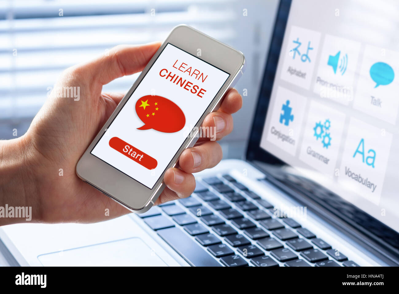 Learn Mandarin Chinese language online concept with a person showing e-learning app on mobile phone with the flag of China Stock Photo