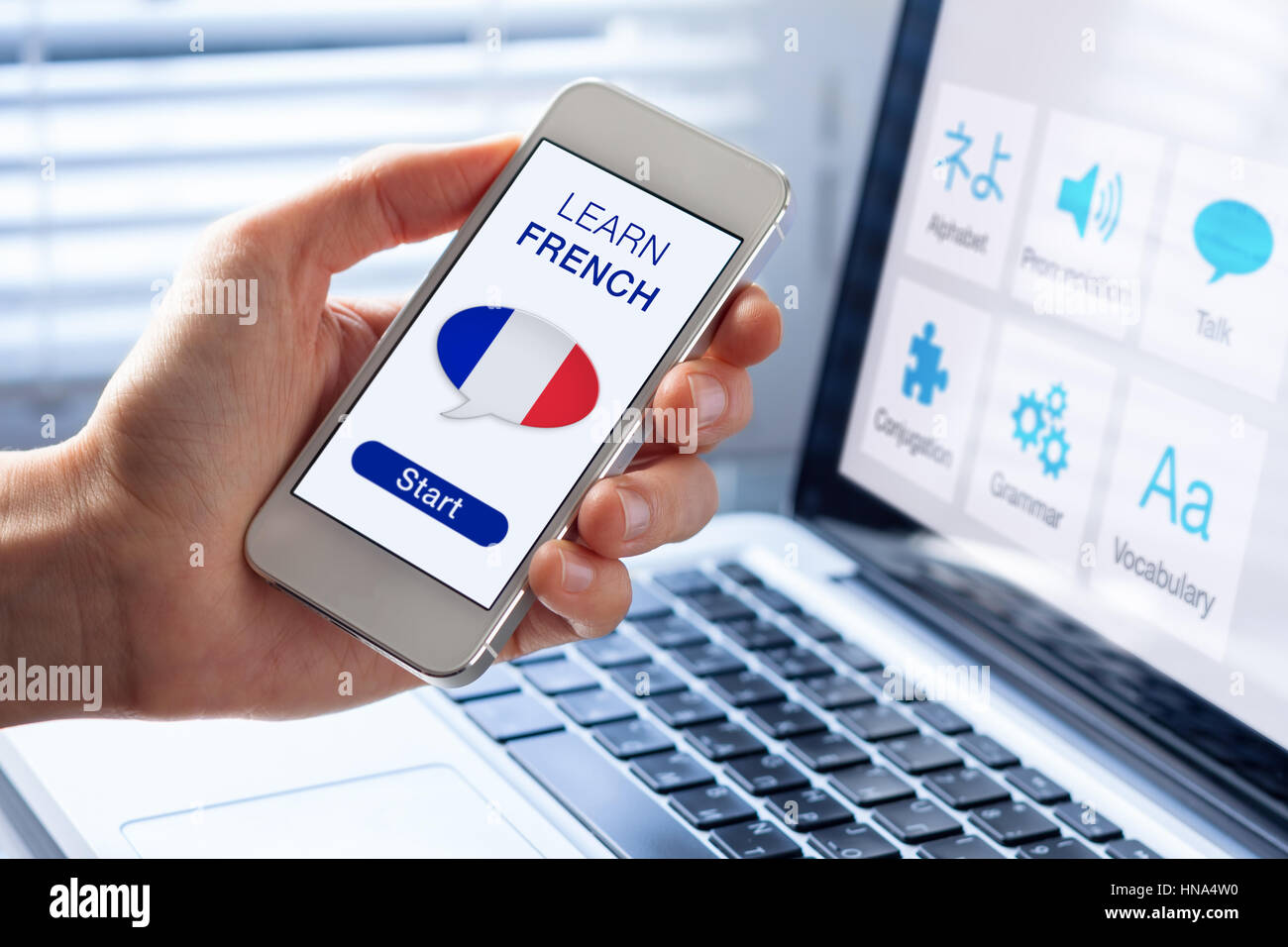 Learn French language online concept with a person showing e-learning app on mobile phone with the flag of France Stock Photo