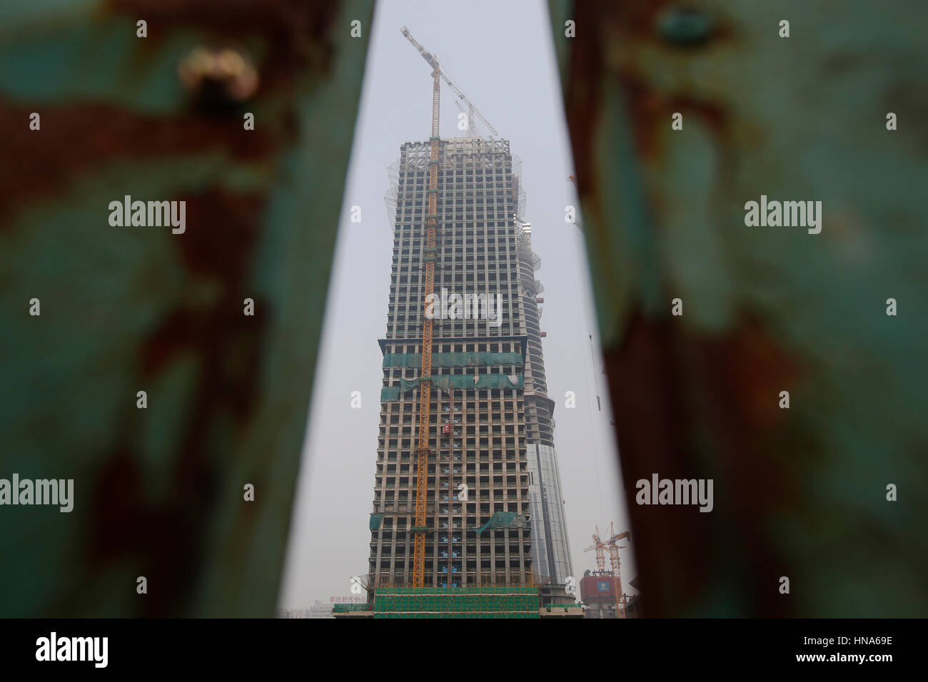 Rusting Building High Rise A high-rise buildings under construction stands behind a rusting metal ...