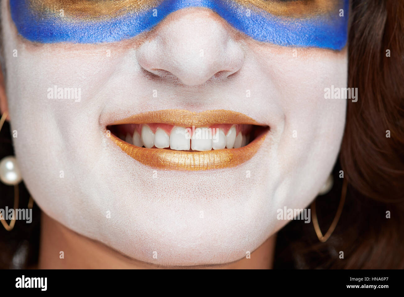 close up of woman smile with golden painted lips and white skin Stock Photo