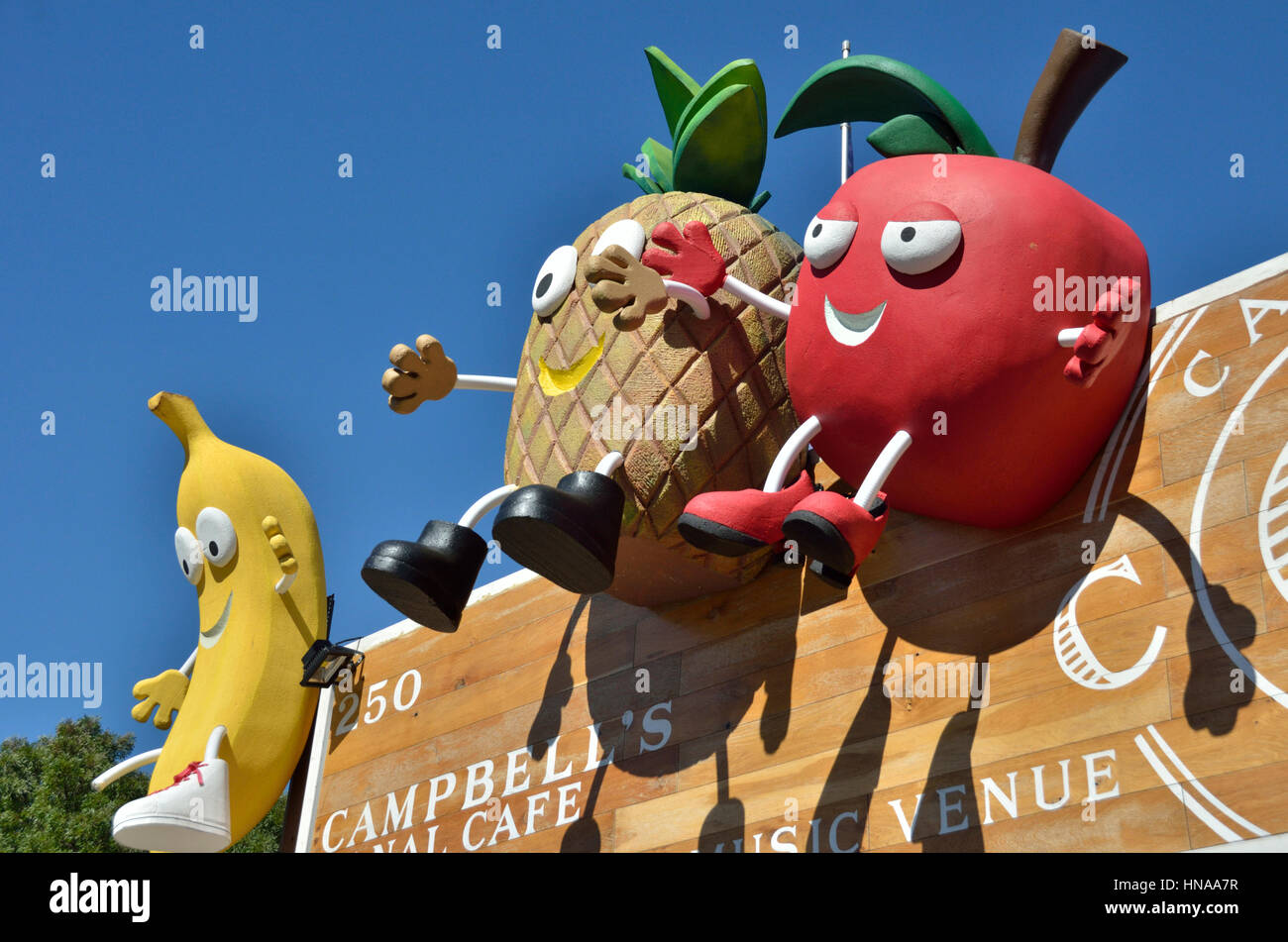 Colourful fruit and vegetable cartoon characters outside a vegan, cafe Stock Photo