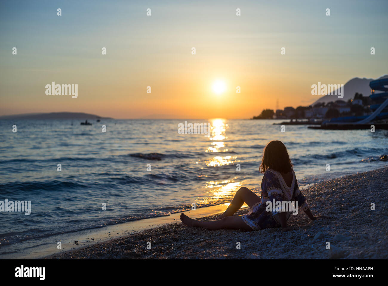young woman on the beach at sunset Stock Photo - Alamy