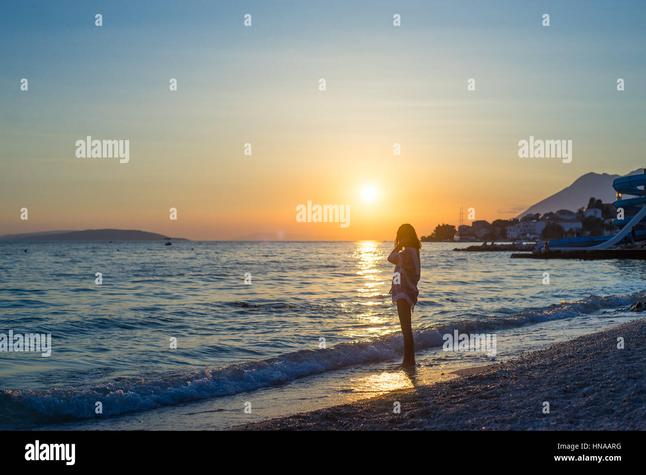 young woman on the beach at sunset Stock Photo - Alamy