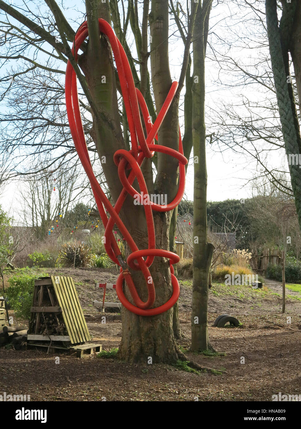 Red plastic tubing used as a climbing frame in school garden or playground Stock Photo