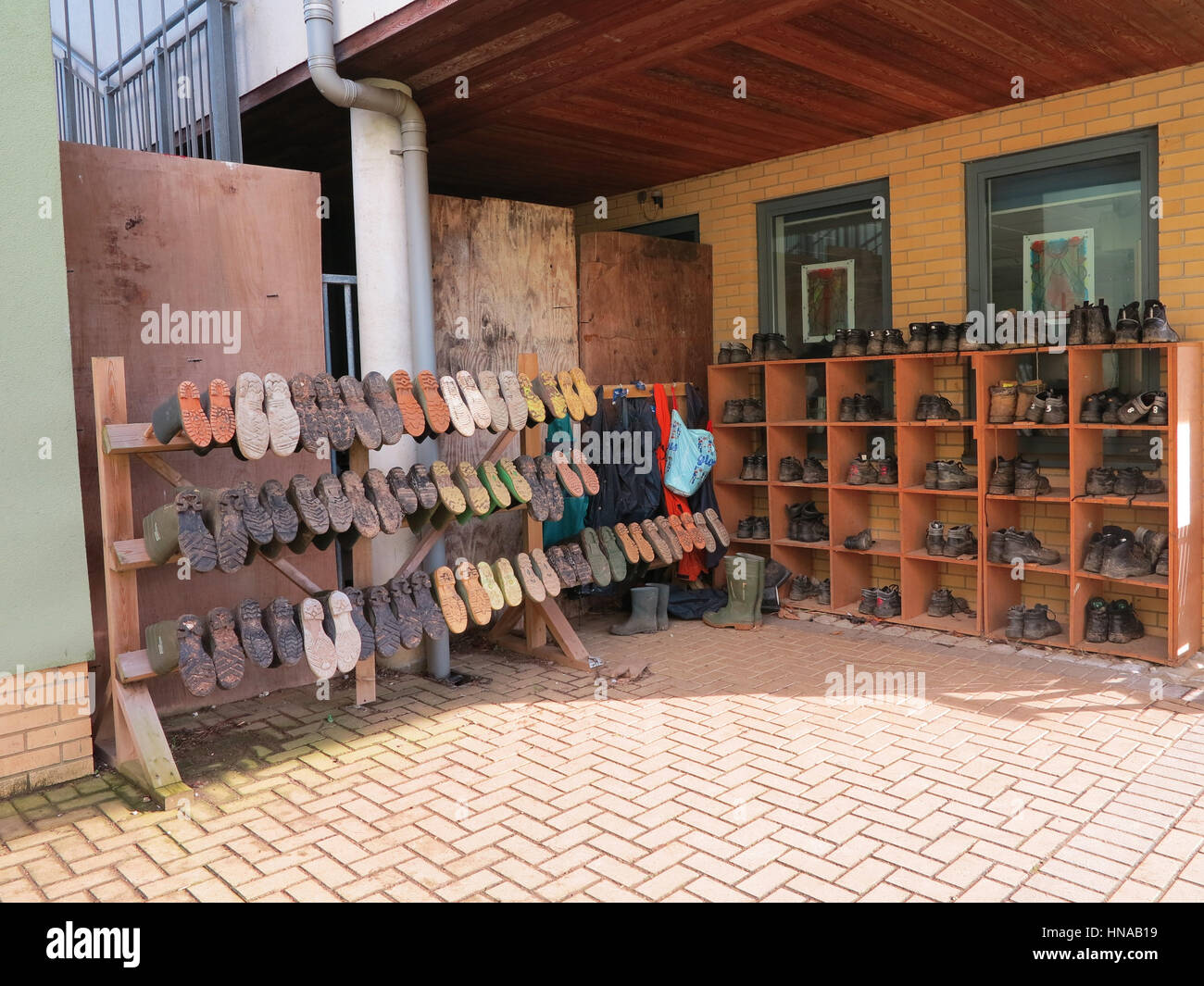 Rows of wellies and outdoor shoes belonging to a school children's gardening club Stock Photo