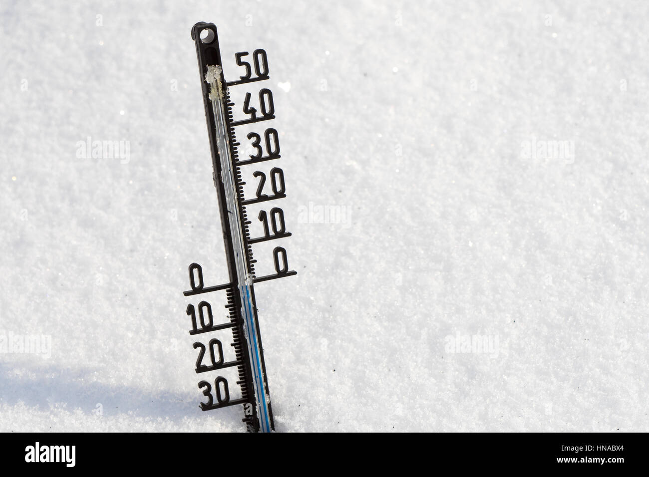 Thermometer on snow shows low temperatures under zero in degrees Celsius Stock Photo