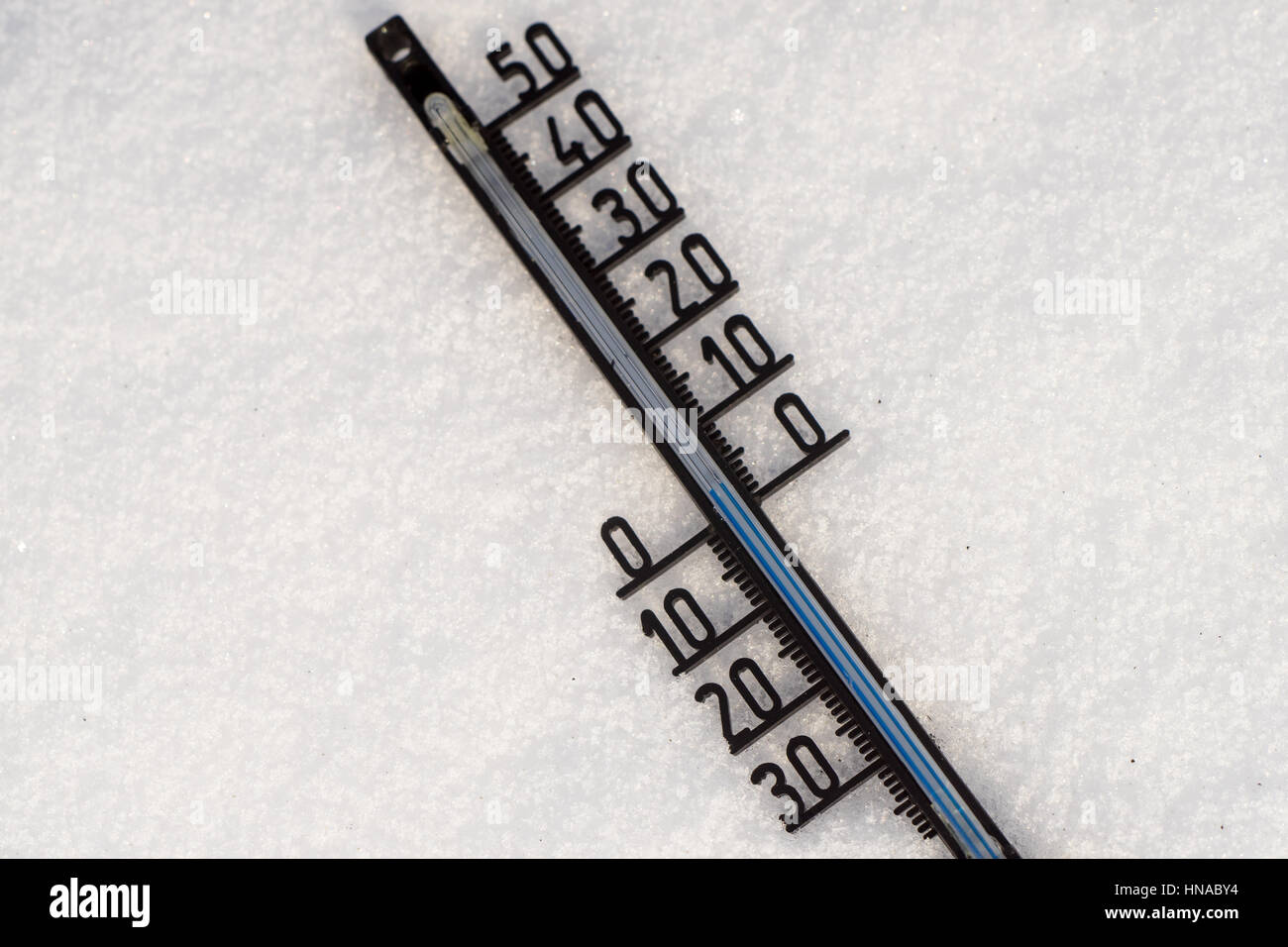 Thermometer on snow shows low temperatures in degrees Celsius Stock Photo