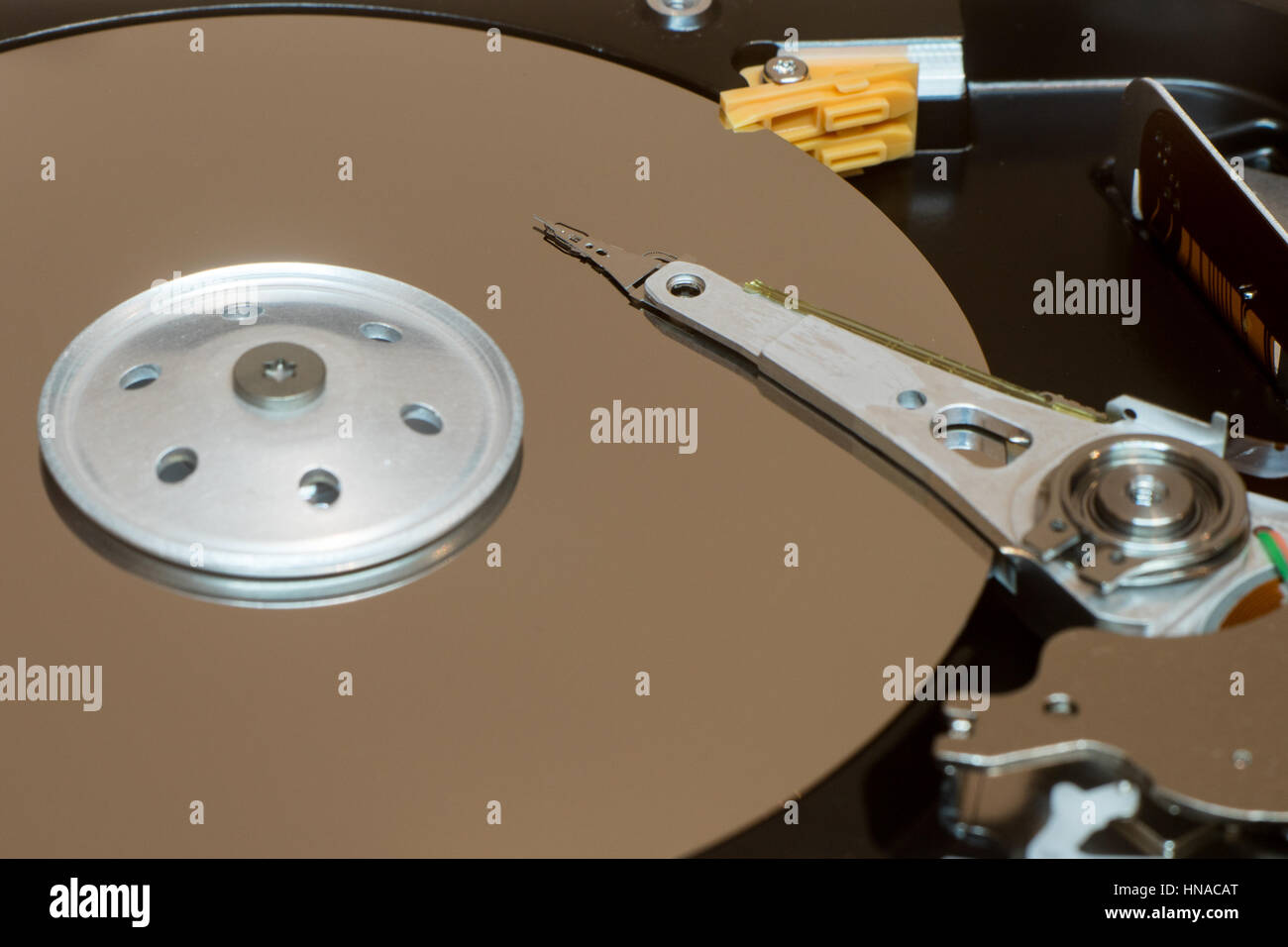 Close up inside of computer disk drive HDD . Detail of writing and reading head on acuator arm and axis, spindle and platters Stock Photo