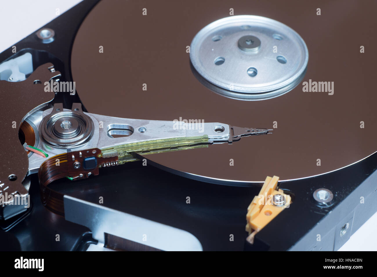 Close up inside of computer disk drive HDD . Detail of writing and reading head on acuator arm and axis, spindle and platters Stock Photo