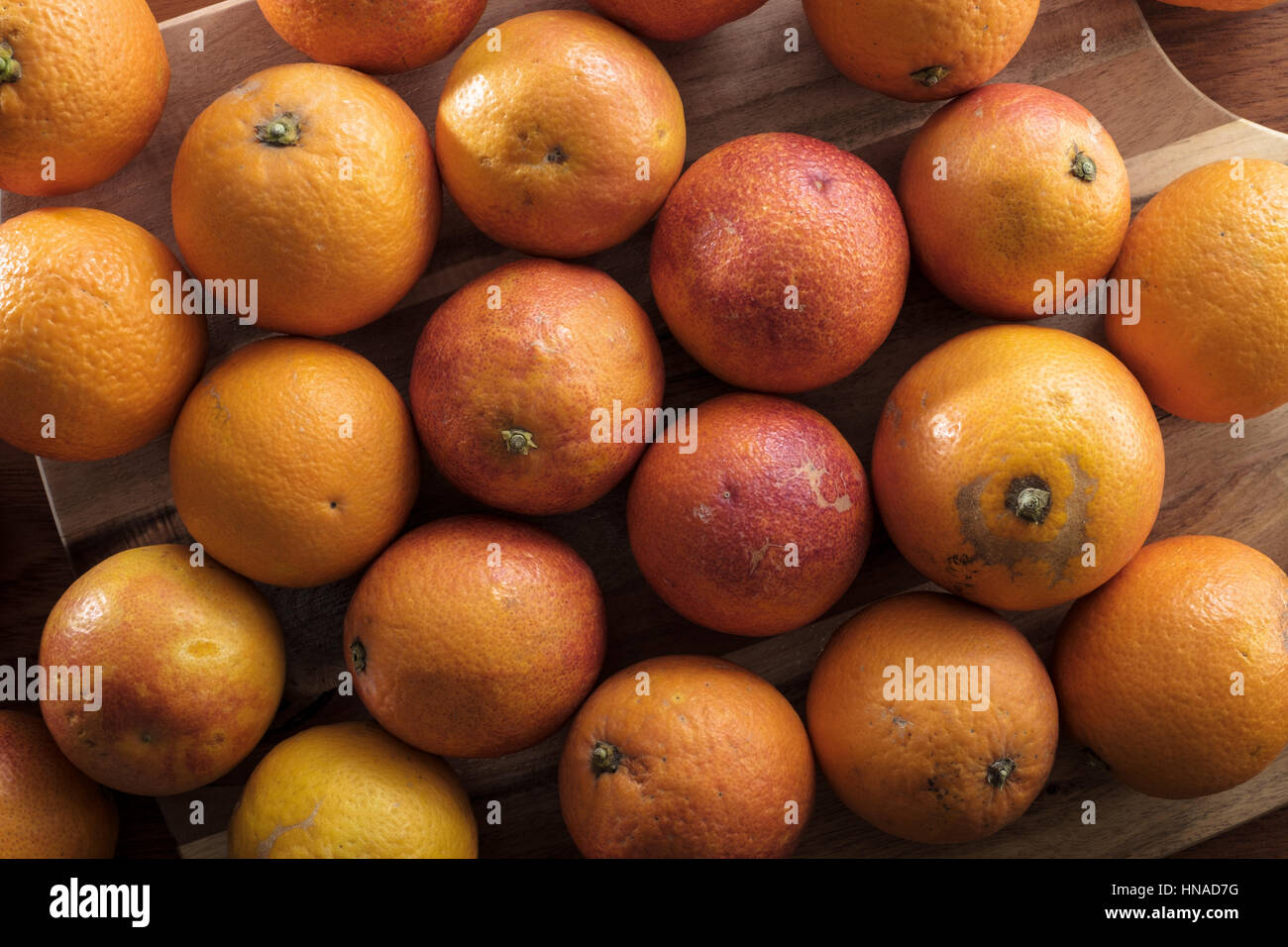 Over a dozen red oranges on cutting board Stock Photo