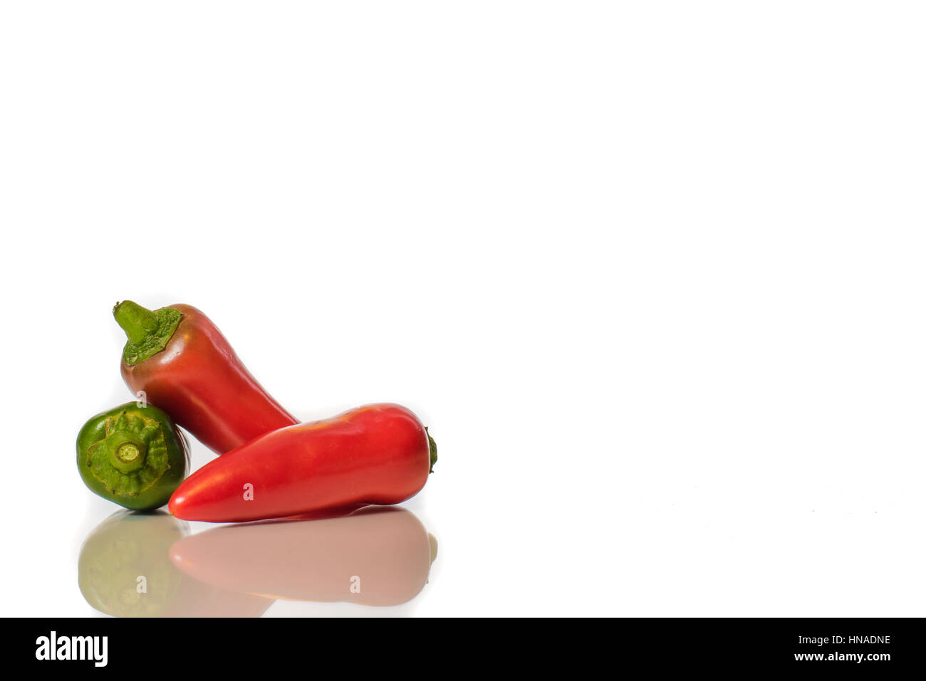 Red and Green chilli peppers against a white background Stock Photo