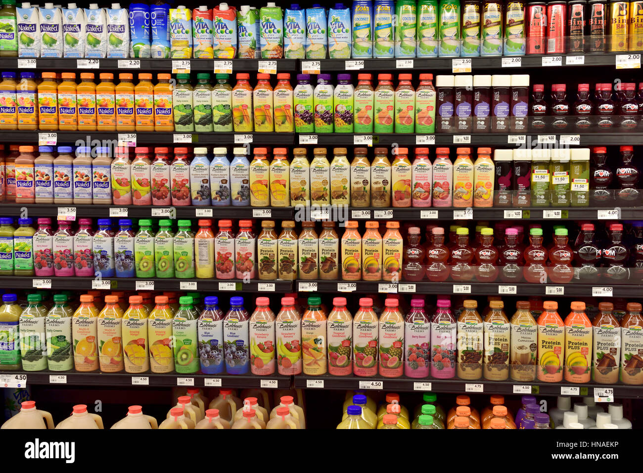 Bottles of fruit drinks on supermarket shelves Stock Photo