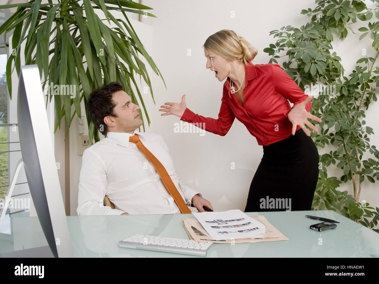 Auseinandersetzung zwischen Geschaeftsmann und Geschaeftsfrau im Buero - conflict in office Stock Photo