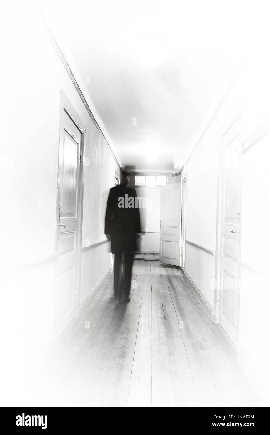 Man in black motion blur walking in a white hospital coooridor