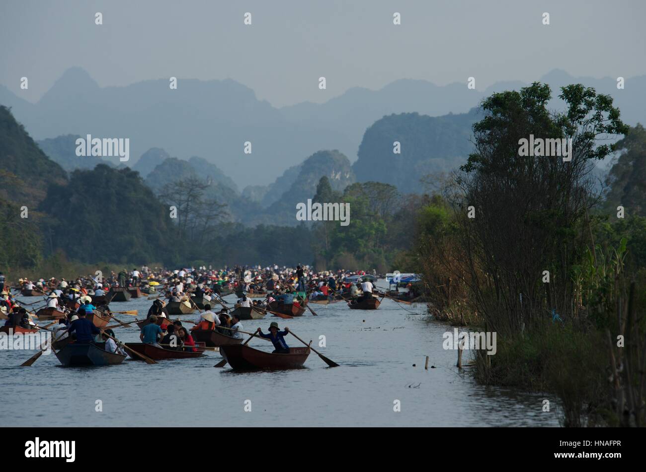 Two men fishing from small boat with net and paddle Yen River leading to  Perfume Pagoda near Hanoi north Vietnam Stock Photo - Alamy