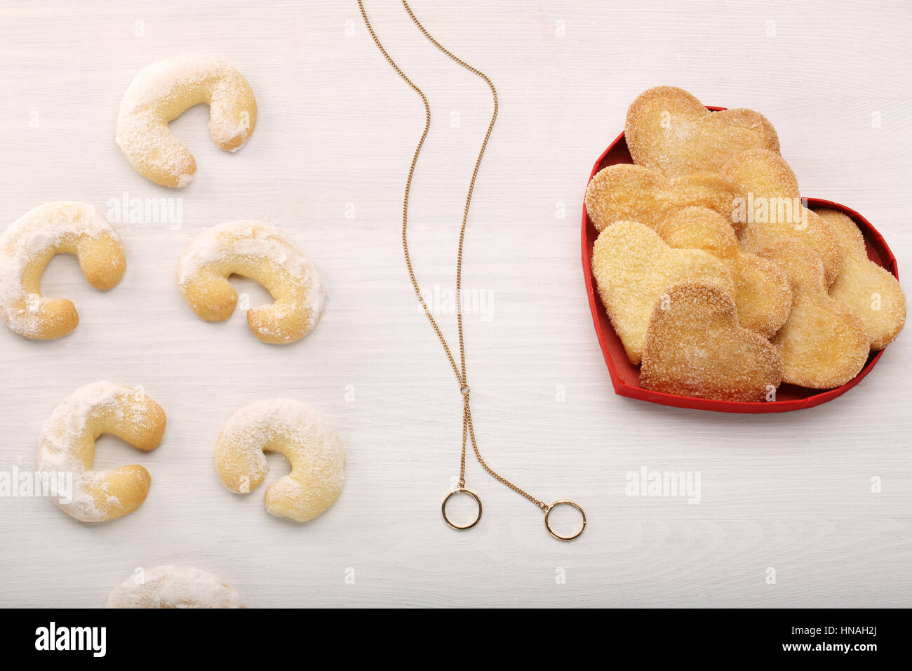 Delicious crunchy cookie in hearts shapes and necklace with wedding rings Stock Photo