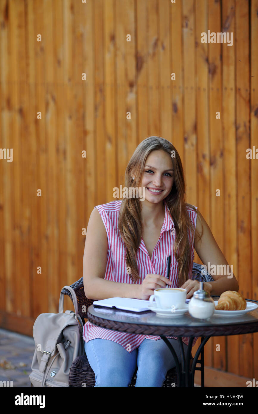 Smilling girl sitting on the table in cafe Stock Photo - Alamy