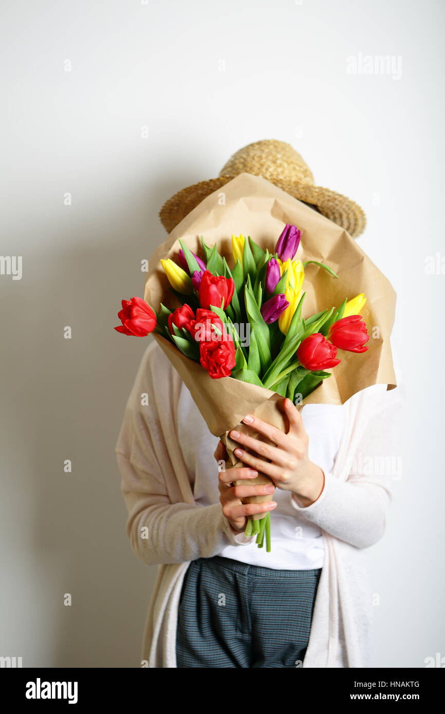 Standing girl covered her face with a bouquet of bright flowers Stock ...