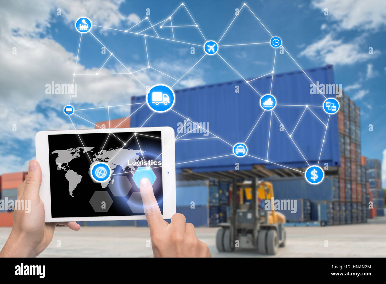 Hand holding tablet is pressing button Logistics connection technology interface global partner connection for logistic import export background. Busi Stock Photo