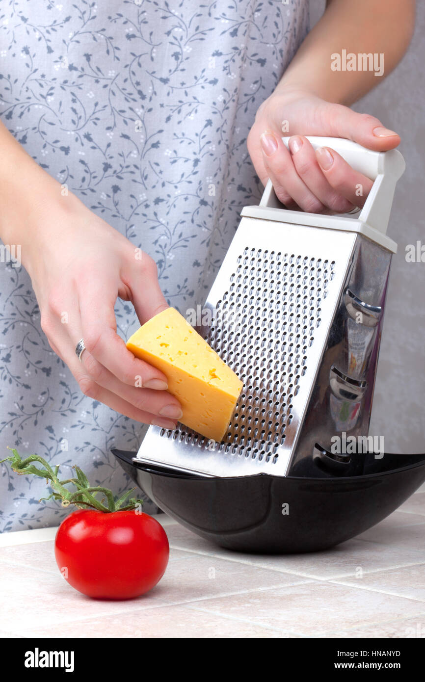 Hands using a cheese grater Stock Photo - Alamy