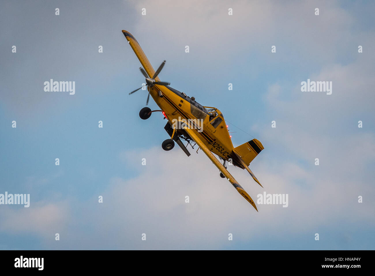 A crop-duster plane flies over a farm and coats crops with pesticides in Secretary, Maryland. Stock Photo