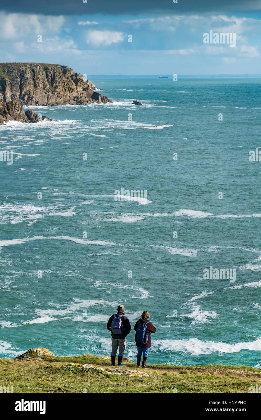 Two walkers stand on the coast of Gwennap Head in Cornwall, England. Stock Photo